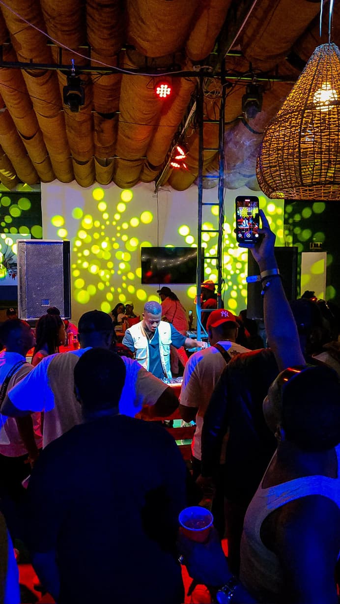 A packed crowd under a thatched roof at one of TAPIWA's sets